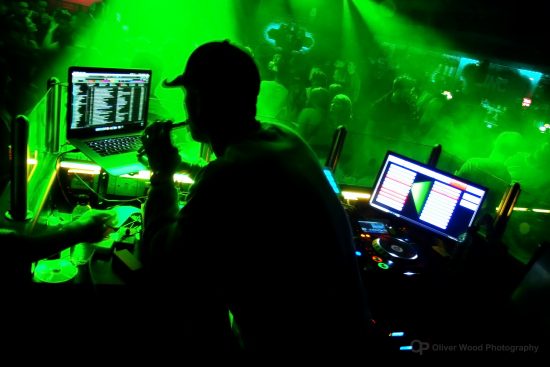 Nightclub interior with silhouette of dj and green light