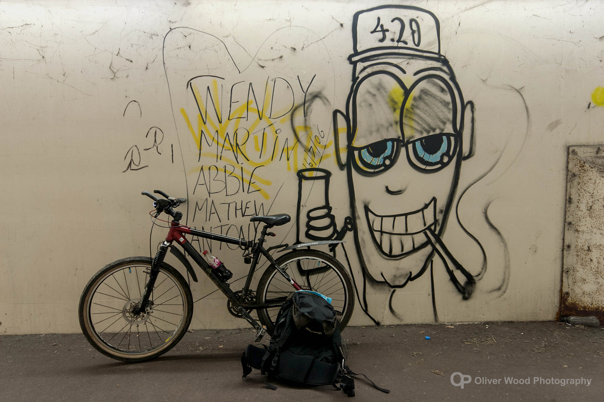 graffiti on a wall of a man wearing cap with a mountain bike