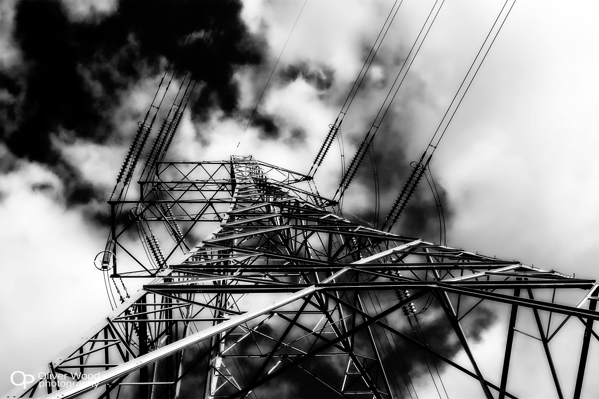 Black and white photo of an electricity pylon and clouds, very high contrast