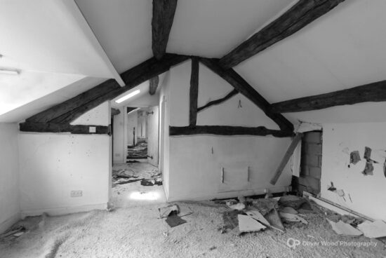 Black and white image of an old bedroom with timber frame