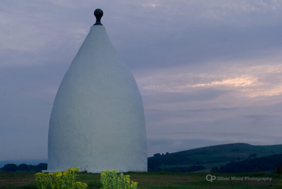 White nancy against a pale low-light sky with bands of light.