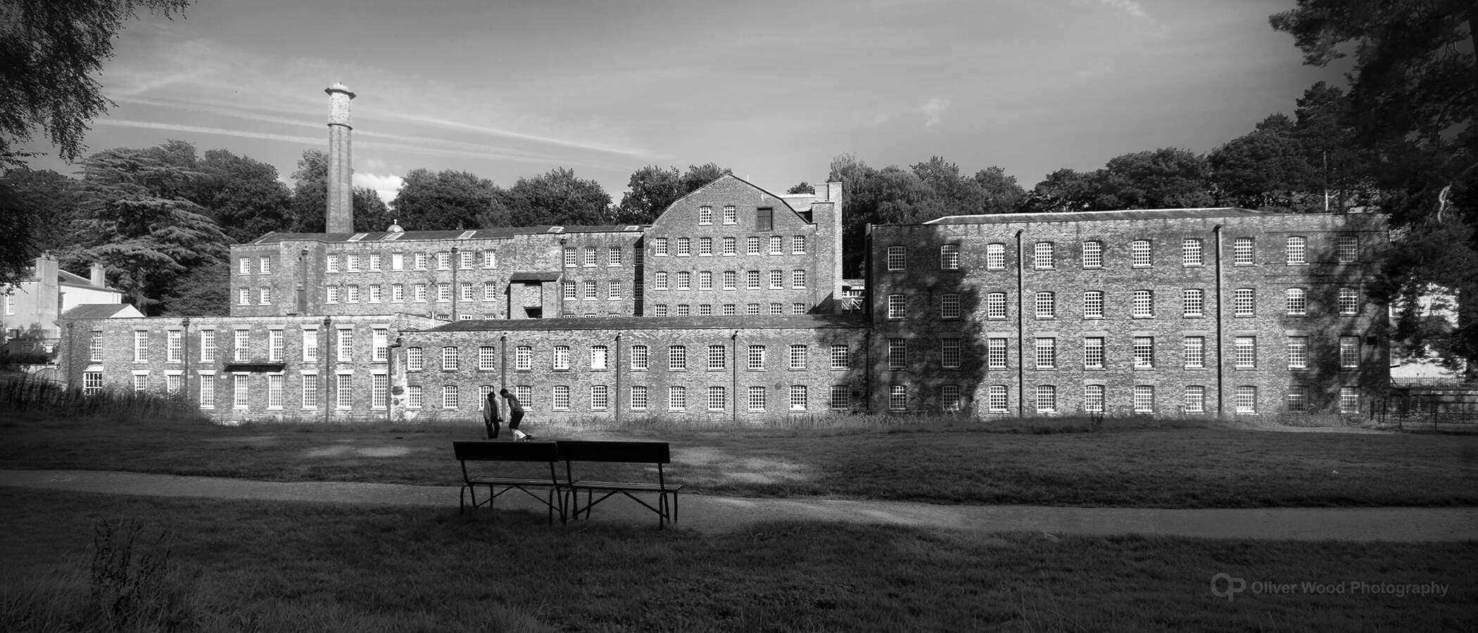 A black and white image of quarry bank mill with dark foreground. 