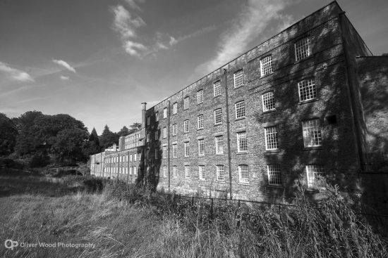 Black and white picture of a large old mill. 