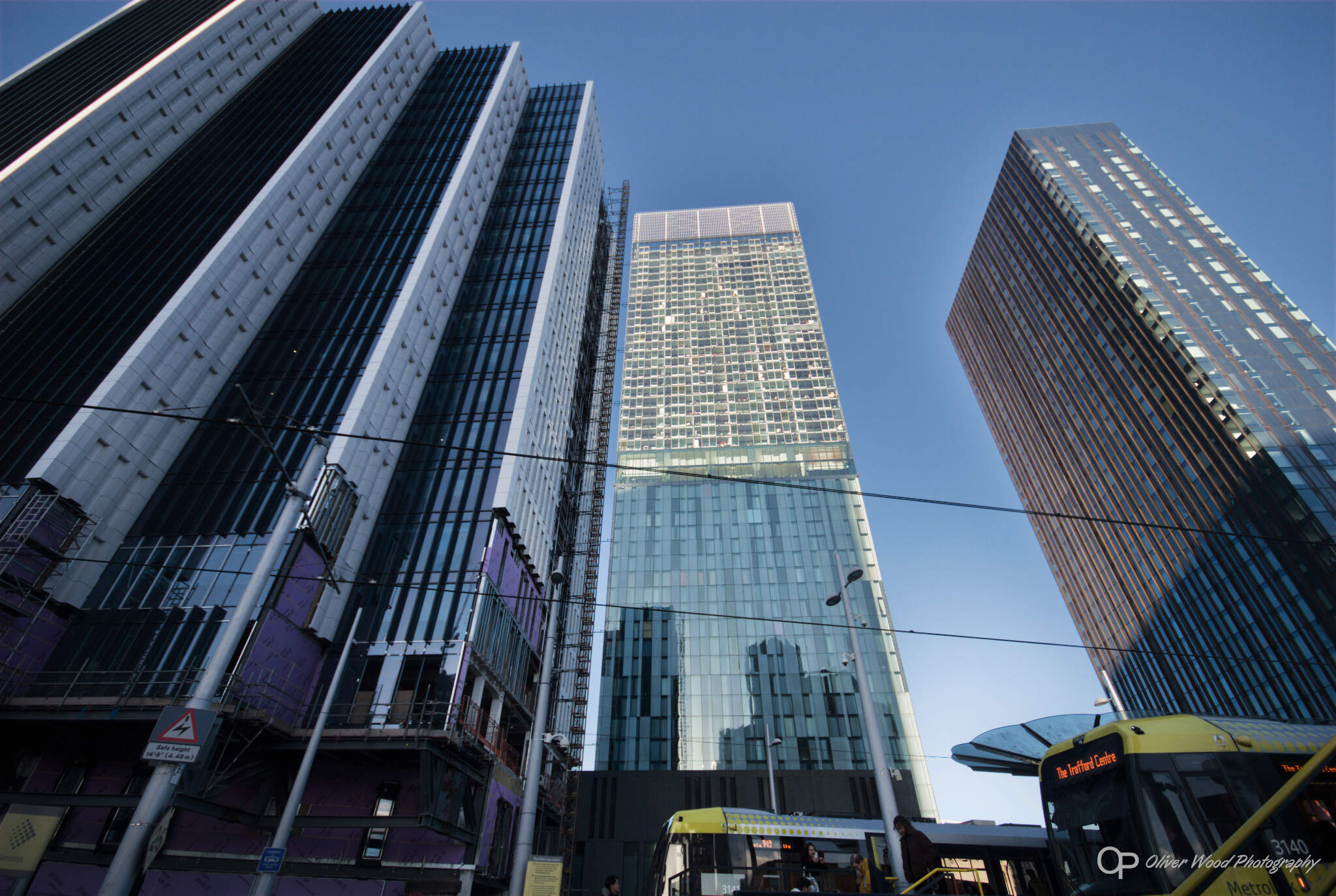 A picture of tall green and grey glass buildings against a blue sky