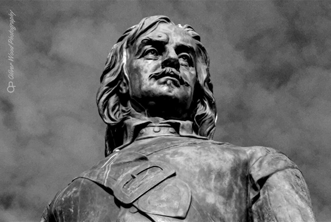 A black and white image of the face of Oliver Cromwell's bronze statue.
